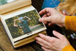 Leinwandbild Motiv Photo printing concept. Female hands adding printed photo to picture album.
