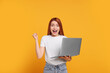 © New Africa - Happy young woman with laptop on yellow background