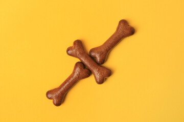 Wall Mural - Bone shaped dog cookies on orange background, flat lay