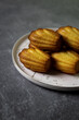 Madeleine cakes on a pink plate on a grey table