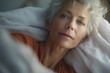 © wetzkaz - elderly old woman in bed, teary eyes, angry or sad, tired or powerless, dying dead and dead, gray hair, alone on white pillow and bed cover. Generative AI