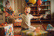 © wetzkaz - little kid laughing and looking forward smiling, hands and arms up with joy, birthday and birthday gifts. Generative AI