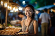 © wetzkaz - young adult woman or teenager, asian, food vendor on local market, fictional tropical location. Generative AI
