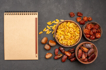 Wall Mural - top view different tasty raisins from grape and other fruits on a grey background dry fruit raisin food