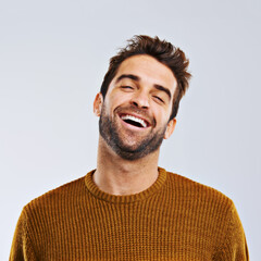 Wall Mural - Laughing, comedy and portrait of happy man by white background. Smile, confident and face laugh of comic person, isolated and young male model enjoying a comedy joke on a studio backdrop