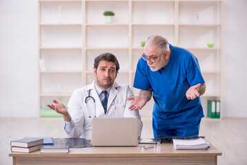 Wall Mural - Two male doctors in telemedicine concept