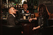 © alexkoral - happy man and a woman with glasses of beer communicate with bartender at bar counter in a pub