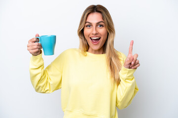 Wall Mural - Young Uruguayan woman holding cup of coffee isolated on white background pointing up a great idea