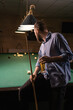 © Andrii Lysenko - Millennial man having fun in a night out in billiards club and drinking beer