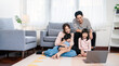© paulaphoto - Portrait of young Asian family father mother daughter looking at tablet computer in living room floor, little asian girl use laptop with parents. Weekend holiday leisure time education, work from home