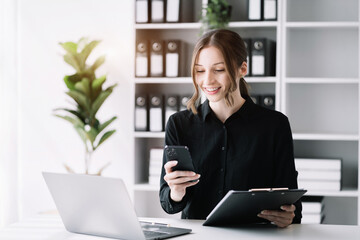 Businesswoman working with smart phone and laptop and digital tablet computer in office.