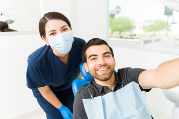 Wall Mural - Smiling patient and woman dentist taking a selfie