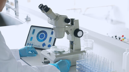 Poster - A man observing with a microscope. Scientific experiment.