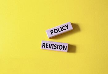 Canvas Print - Policy revision symbol. Concept word Policy revision on wooden blocks. Beautiful yellow background. Business and Policy revision concept. Copy space