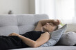 Peaceful serene mature woman lying on back on sofa with closed eyes, sleeping on home comfortable couch, resting in living room with hand oh head, enjoying relaxation, break, leisure, weekend