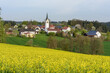 canvas print picture - Dorf mit Kirche, mit Rapsfeld im Vordergrund