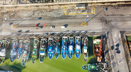 Wall Mural - Fishing boats in a small port, aerial overhead view from drone.