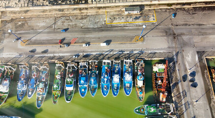 Canvas Print - Fishing boats in a small port, aerial overhead view from drone.