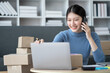 © PaeGAG - Online business owner woman answer phone call with customer while working with orders.