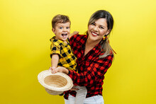 Mother And Her Baby Son Celebrating The Brazilian Festa Junina. Portrait Of A Woman And Her Son Wearing Typical Clothes And A Straw For The Traditional June Festival In Brazil.