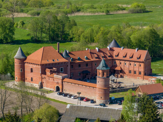 Tykocin castle on sunny day surrounded with green meadows and trees - drone aerial photography Poland