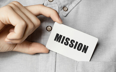 Poster - Man putting a card with text MISSION in the pocket