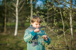 © Alina Lebed - A funny boy walks through the spring park, examines the leaves with a large magnifying glass, looks for bugs and enjoys.