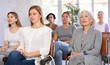 © JackF - Adult woman and elderly women in casual clothes listens to lecture while sitting on chair in office