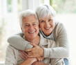 © Anne B/peopleimages.com - Portrait, smile and senior couple with love, hug and romance with retirement, relationship and bonding. Face, happy mature woman and elderly man embrace, home and marriage with commitment and loving