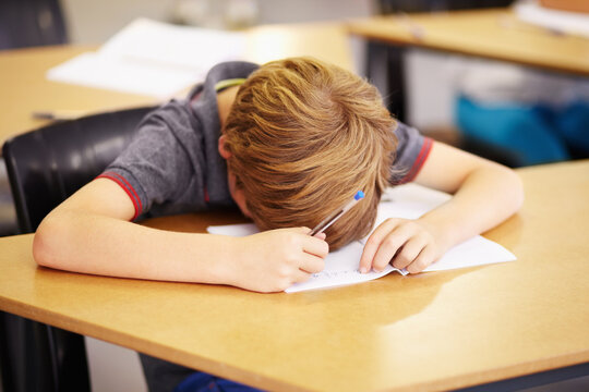 Sleeping, bored and tired with boy in classroom for learning, education and knowledge. Stress, anxiety or confused with male student at desk in school adhd for exhausted, autism problem or frustrated