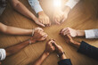 © Donson/peopleimages.com - Support, diversity and people holding hands by a table at a group counseling or therapy session. Gratitude, trust and friends in a circle for praying together for religion, community and connection.