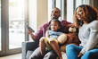 © Donson/peopleimages.com - Love, smile and family on a couch, watching tv and bonding on a weekend break, home or chilling. Happy parents, mother or father with kid, female child or daughter on a sofa, happiness and television