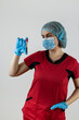 © RomanR - woman doctor wear red uniform, mask protection and gloves hold test tube with blood sample