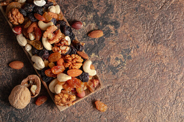 Sticker - Mix of nuts and raisins on a brown rustic background.