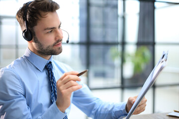 Sticker - Cheerful young support phone male operator in headset, at workplace while using computer, help service and client consulting call center concept