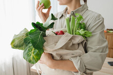 Woman Holding Reusable Bag Full Of Organic Vegetables And Fruits