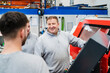 © Westend61 - Smiling employee with colleagues by CNC machine at factory