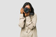 Young Indian photographer woman holding a professional camera isolated