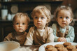 Three small cute children, standing in the kitchen