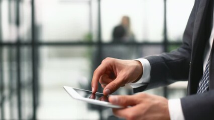 Midsection of businessman using digital tablet in office.