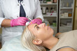 © Chiralli - Cosmetologist holds syringe for cosmetic injections lifting skin turgor liposuction biorevitalization mesotherapy beauty procedures to client in salon