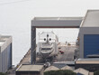 Super Yacht hauled out in shipyard, being lifted by industrial crane for refit or maintenance yard period