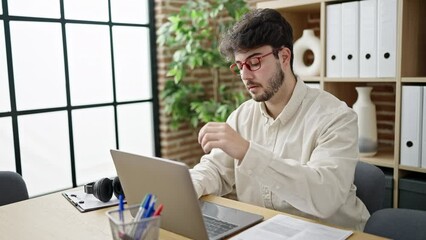 Sticker - Young hispanic man business worker stressed using laptop at office