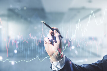 Poster - Man hand with pen working with abstract virtual financial graph on blurred office background, forex and investment concept. Multiexposure