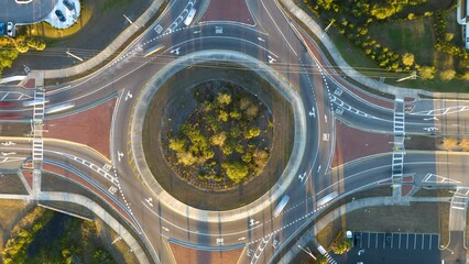 Wall Mural - Aerial view of road roundabout intersection with fast moving heavy traffic. Timelapse of urban circular transportation crossroads