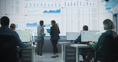 Fototapete - Back View Of Indian Data Analyst And Hispanic Manager Discussing Reports On Digital Screen in Monitoring Room. Male and Female Experts Talking, Employees Working On Computers In Consulting Company
