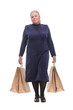 Caucasian senior woman walking with shopping bags smiling at viewer