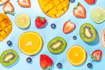 Wall Mural - Summer vitamin food concept, various fruit and berries mango peach mint plum apricots blueberry currant, creative flat lay on light blue background top view copy space