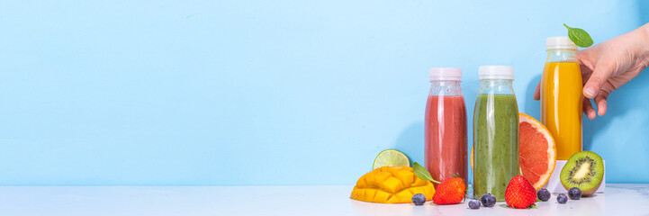  Green, orange and red smoothie in portion bottles, Mix of colourful healthy smoothie or juice drinks of different  fruits: orange, grapefruit, lime, kivi, strawberry, with ingredients