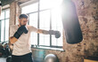 © BullRun - Strong male boxer standing and punching bag in gym